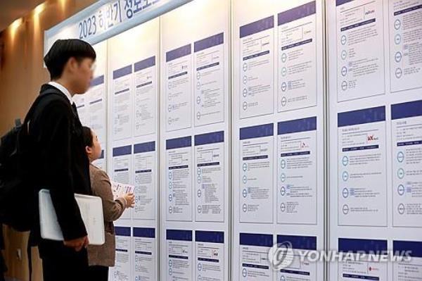 This Nov. 1, 2023, file photo shows jobseekers checking job posts at a job fair. (Yonhap)