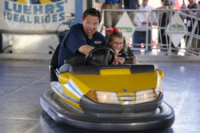 Republican presidential candidate Florida Gov. Ron DeSantis drives a bumper car as his daughter Madison laughs at the Iowa State Fair, Saturday, Aug. 12, 2023, in Des Moines, Iowa. (AP Photo/Jeff Roberson)