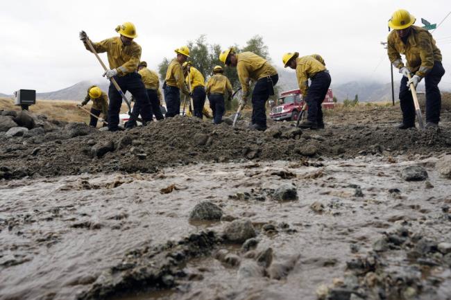 Members of Cal Fire Pilot Rock 6 crew, out of Crestline, Calif., clear mud off the side of the road in the aftermath of Tropical Storm Hilary, Monday, Aug. 21, 2023, in Yucaipa, Calif. (AP Photo/Marcio Jose Sanchez)