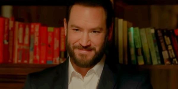 Man Smiling Creepily in front of a bookcase in NBC's Found