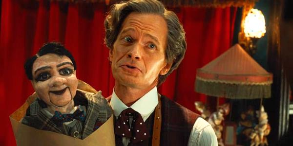 The Toymaker holds up Stooky Bill who's wrapped in kraft paper in Doctor Who.