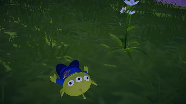 Alien Toy laying in the grass in Disney Dreamlight Valley