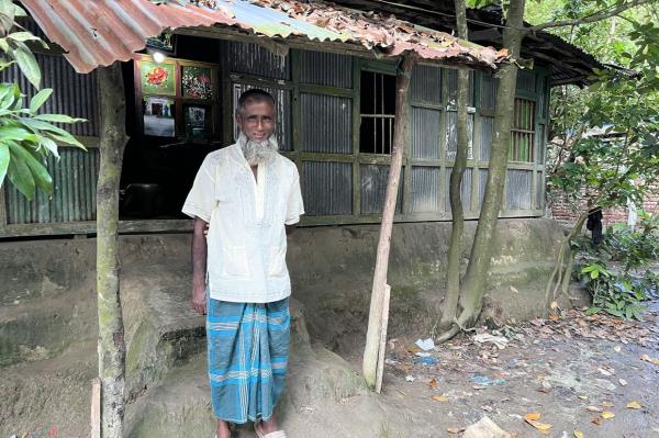 Islam, seen here in front of their one-room home in August 2022, pedals a rickshaw and might make 500 taka on a good day or nothing on a bad day.